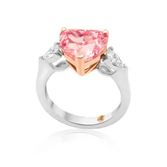 Pink diamond ring is crafted with a heart cut vivid pink diamond as a centerstone and two pear-shaped side diamonds.